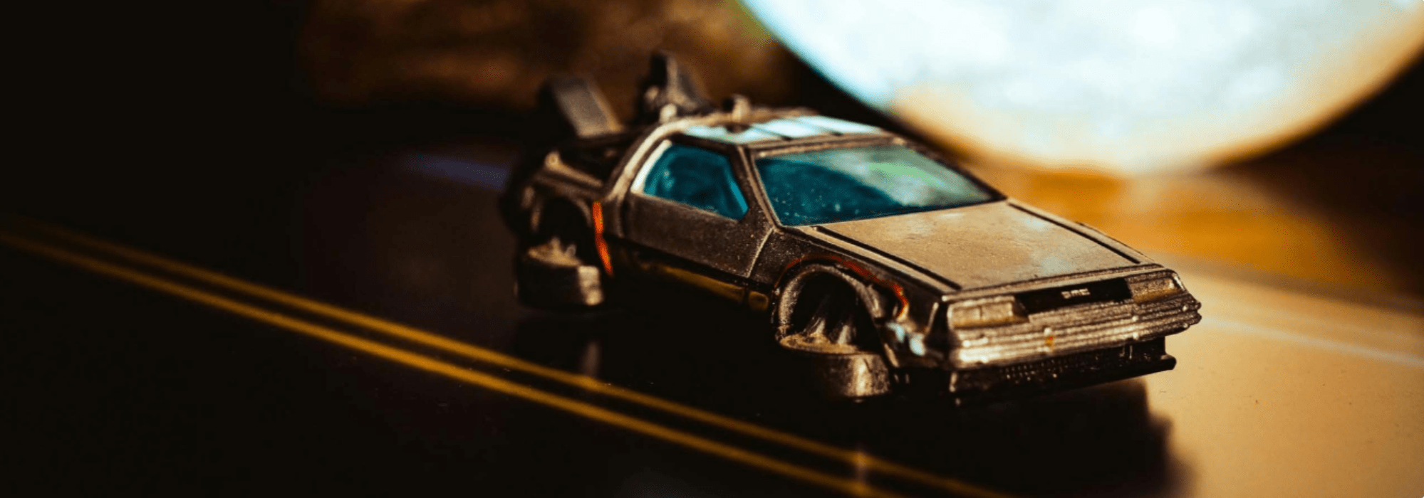 Modelauto van de DeLorean uit Back to the Future op een donkere weg.