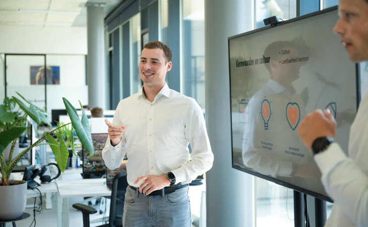 Presentation in white shirt in front of a group.